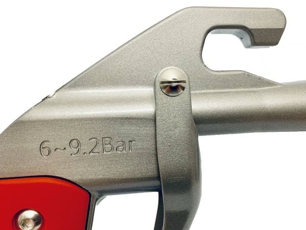 Primo piano di una pistola di pulizia argentata con pressione 6-9,2 Bar.